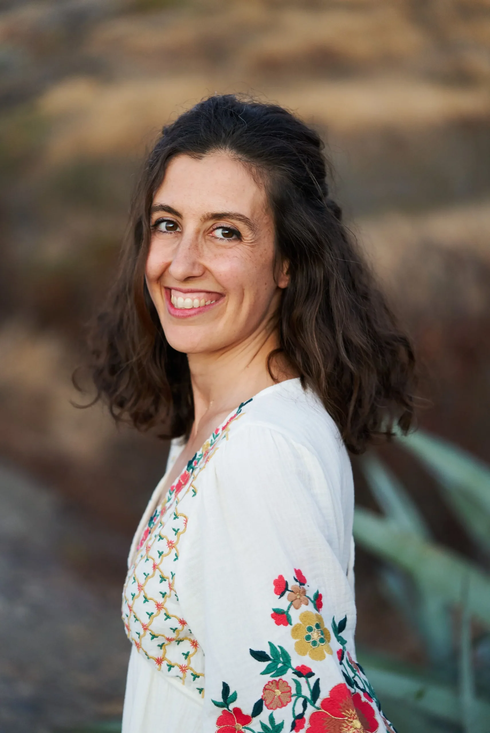Portrait de Silvia Simeone souriante un matin d'été en pleine nature.